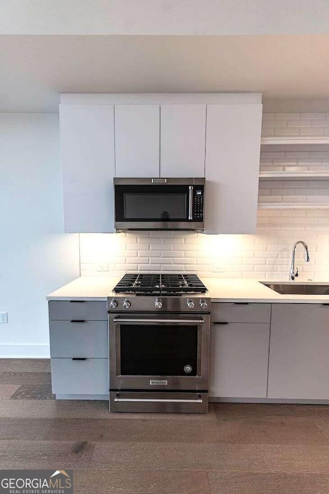 kitchen featuring sink, stainless steel appliances, gray cabinets, and backsplash