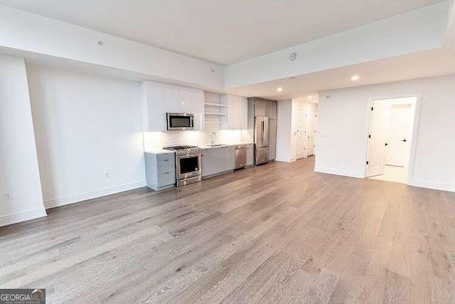 unfurnished living room with light wood-type flooring and sink