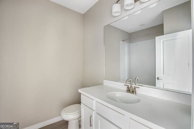 bathroom featuring toilet, vanity, and wood-type flooring