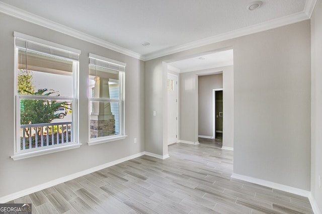 empty room with ornamental molding and light hardwood / wood-style flooring