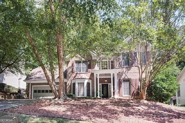 view of front of home featuring a garage, driveway, and brick siding