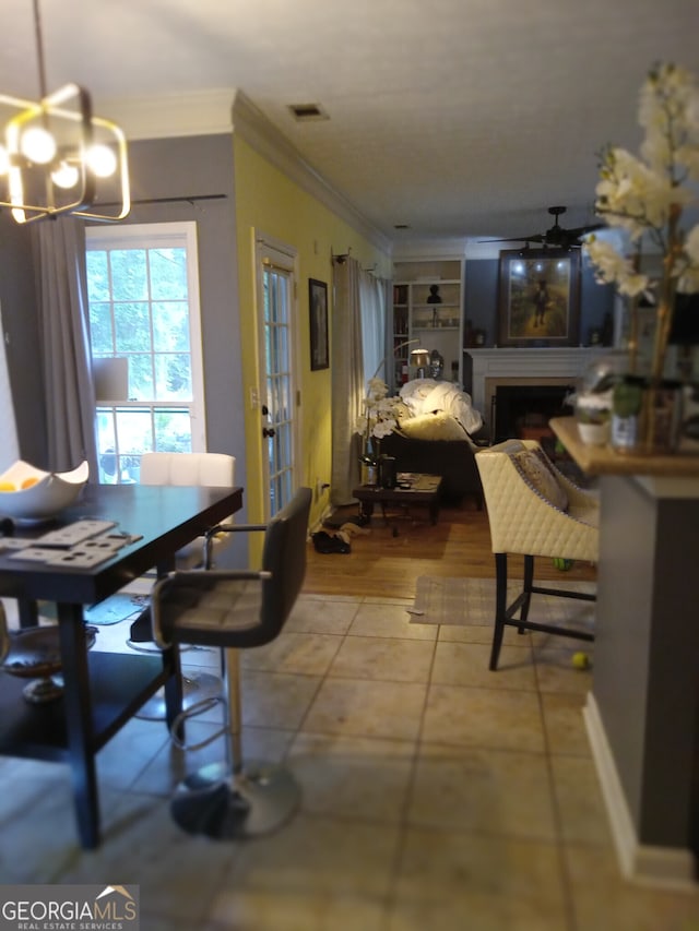 dining space featuring a fireplace, visible vents, a notable chandelier, and ornamental molding