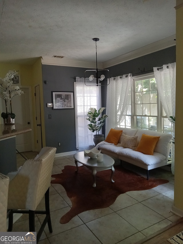 living room featuring visible vents, a textured ceiling, crown molding, a chandelier, and light tile patterned flooring