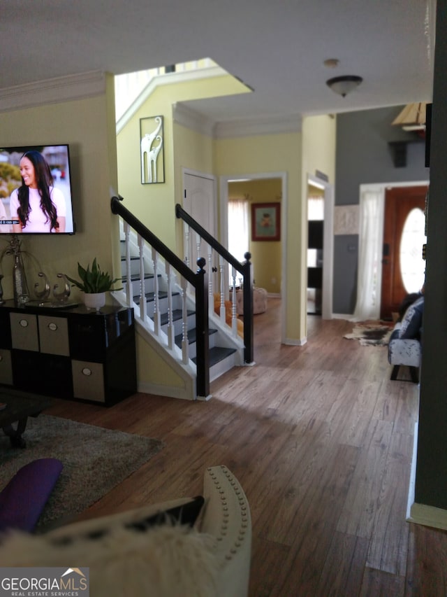 entryway featuring stairs, baseboards, crown molding, and wood finished floors