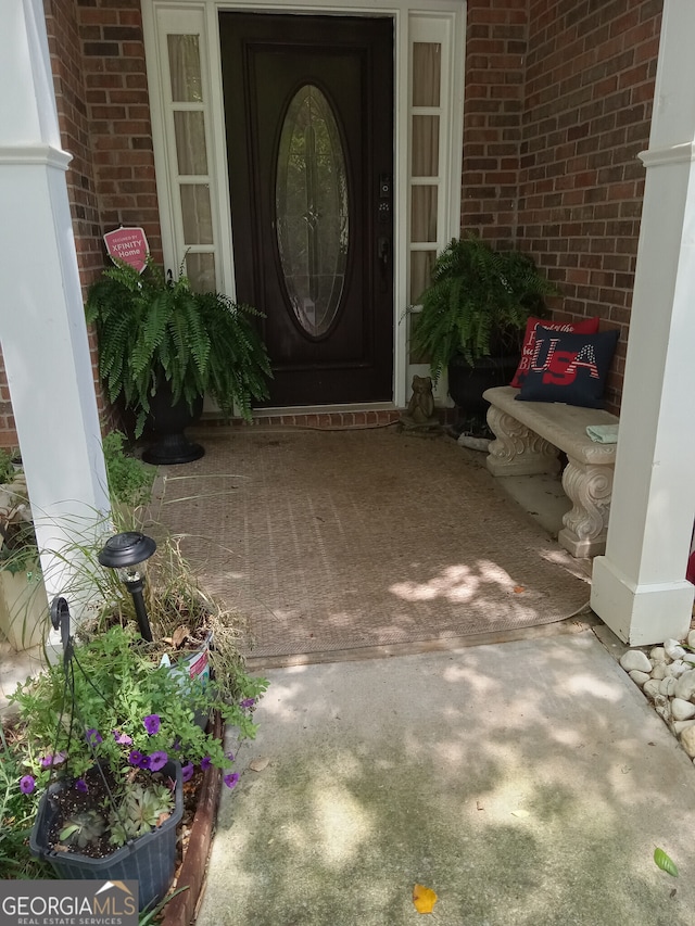 doorway to property featuring brick siding