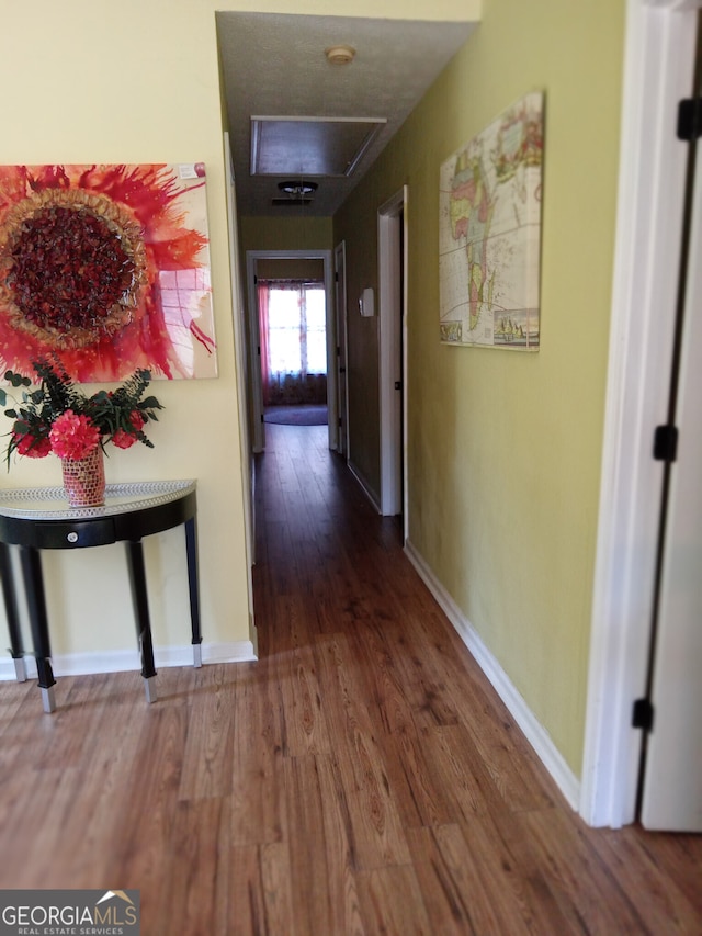 hallway with baseboards and wood finished floors