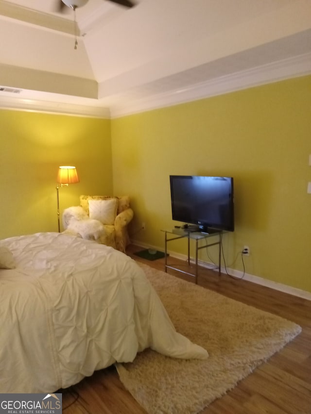 bedroom with baseboards, crown molding, visible vents, and wood finished floors