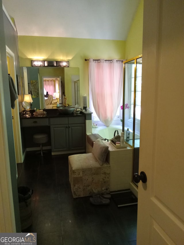 full bath featuring tile patterned floors, vaulted ceiling, and vanity