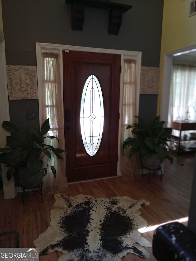 foyer entrance with visible vents and wood finished floors