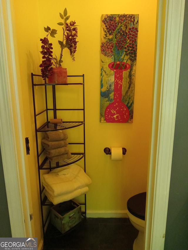 bathroom featuring toilet and baseboards