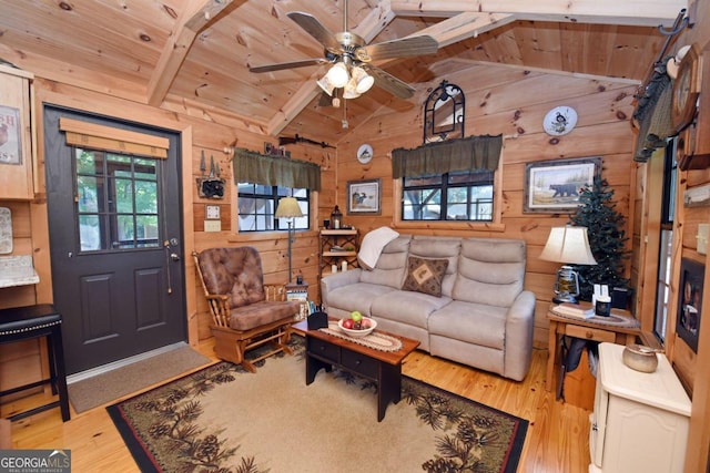 living room featuring wood ceiling, wooden walls, ceiling fan, light hardwood / wood-style flooring, and vaulted ceiling with beams