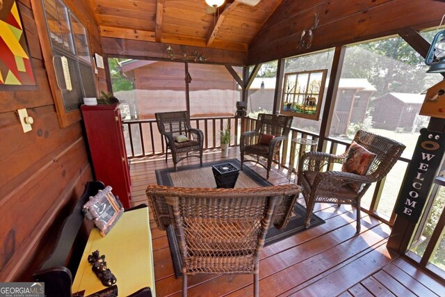 sunroom / solarium featuring a healthy amount of sunlight, lofted ceiling, and wood ceiling