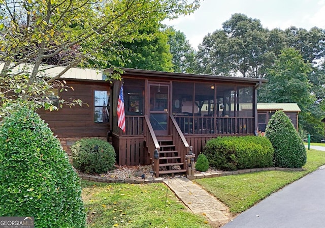 view of front of property featuring a sunroom and a front lawn