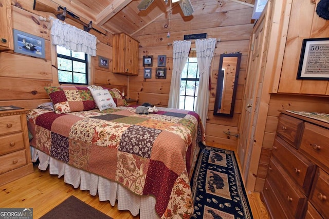 bedroom featuring lofted ceiling with beams, multiple windows, light hardwood / wood-style floors, and wood ceiling