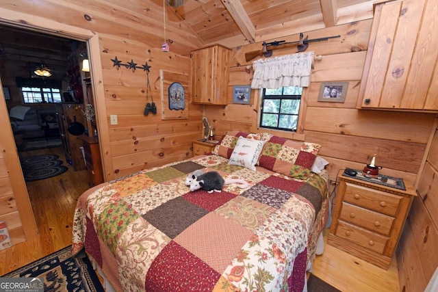 bedroom with wooden ceiling, vaulted ceiling with beams, hardwood / wood-style flooring, and wood walls