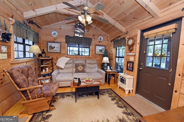 living room featuring vaulted ceiling with beams, wooden walls, wood ceiling, and light hardwood / wood-style floors