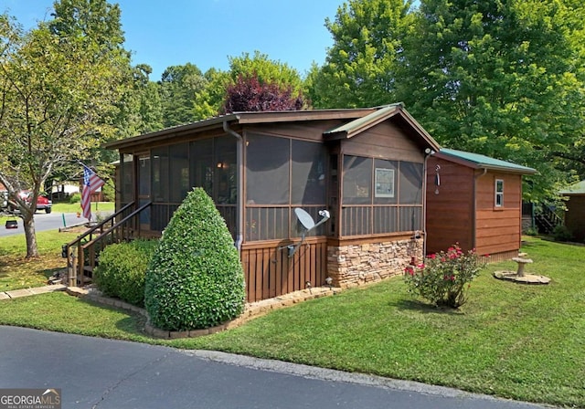 view of front of property featuring a front yard and a sunroom