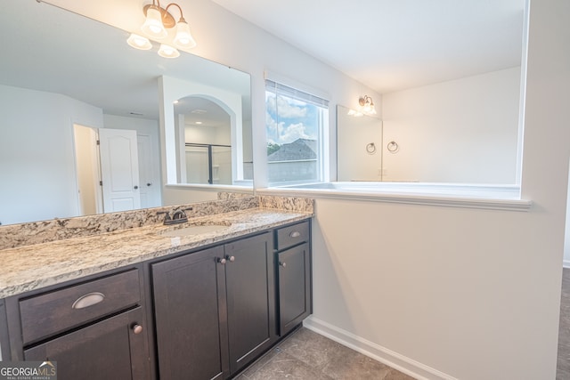 bathroom featuring vanity, an inviting chandelier, and tile patterned flooring