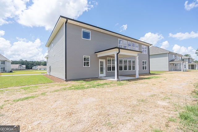 rear view of house featuring a patio and a yard