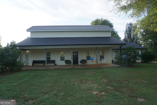 back of property featuring a porch and a lawn