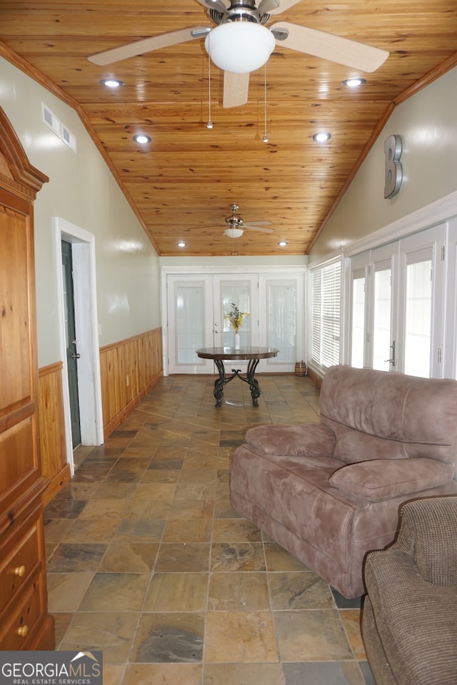 living room featuring french doors, wooden walls, wood ceiling, and crown molding