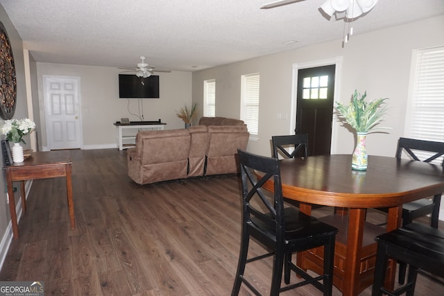 dining area featuring ceiling fan, dark hardwood / wood-style flooring, and a textured ceiling