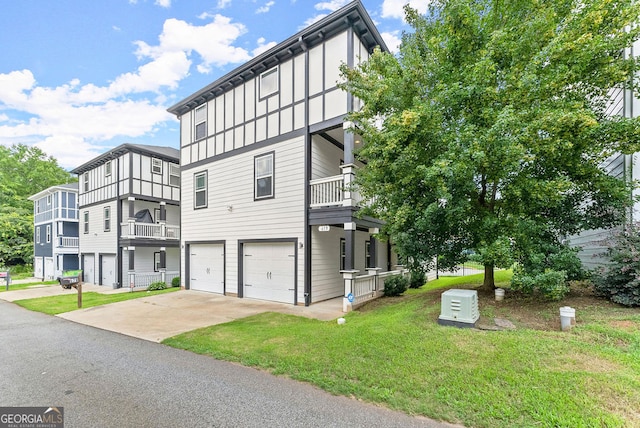 view of front of property featuring a front yard, a garage, and a balcony