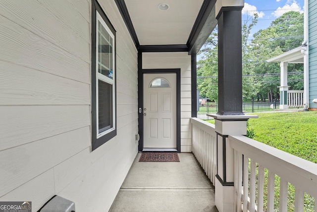 entrance to property featuring a porch and a yard