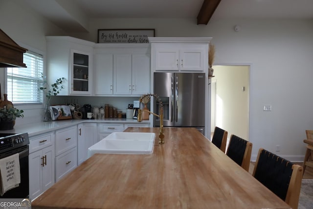 kitchen featuring sink, white cabinetry, beam ceiling, stainless steel fridge with ice dispenser, and range with electric cooktop