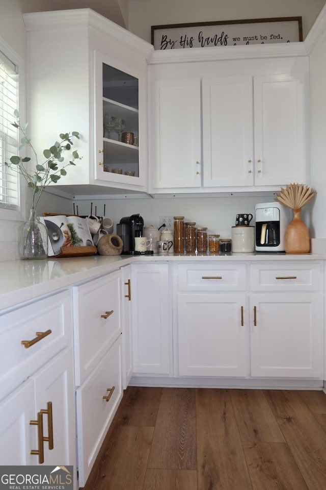 kitchen featuring white cabinets, dark hardwood / wood-style floors, and light stone countertops