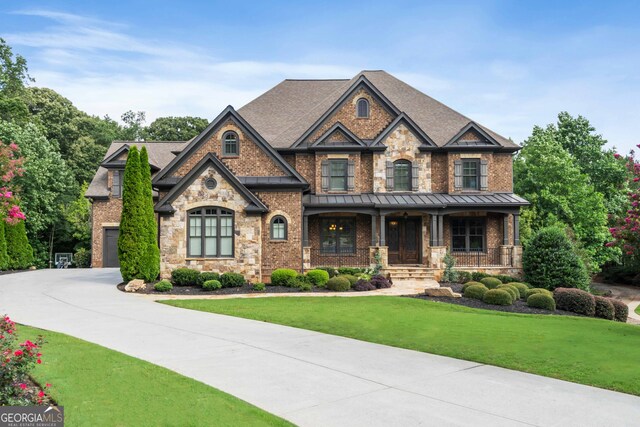 craftsman-style home featuring a front yard, a garage, and covered porch