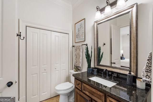 bathroom with ornamental molding, vanity, and toilet