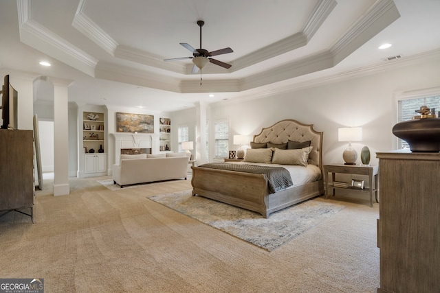 carpeted bedroom featuring a tray ceiling, ceiling fan, and ornamental molding