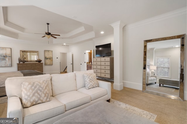 living room with ceiling fan, a raised ceiling, ornamental molding, and light carpet