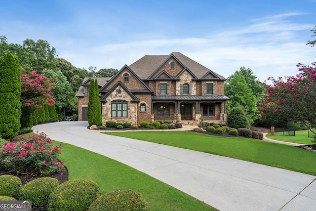 craftsman inspired home featuring covered porch and a front yard