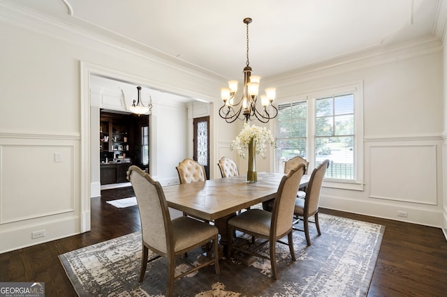 dining space featuring ornamental molding, an inviting chandelier, and dark hardwood / wood-style floors