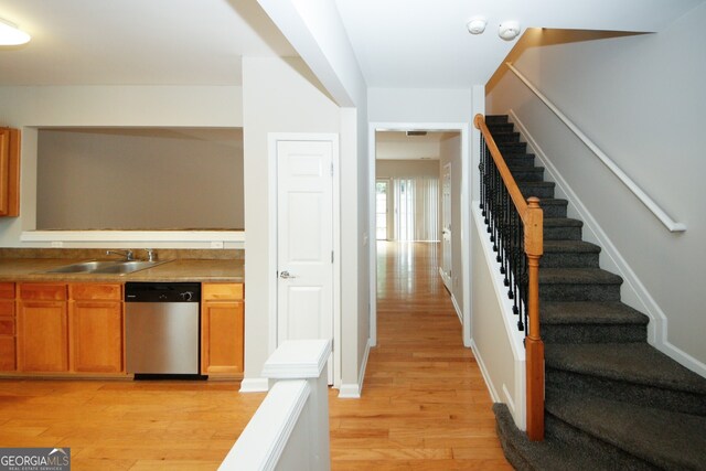 kitchen featuring light wood-type flooring, sink, and dishwasher