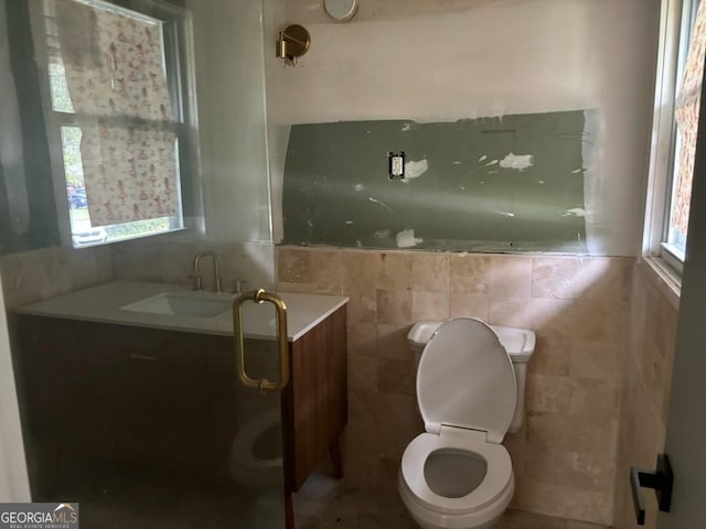 bathroom with vanity, tile walls, and toilet