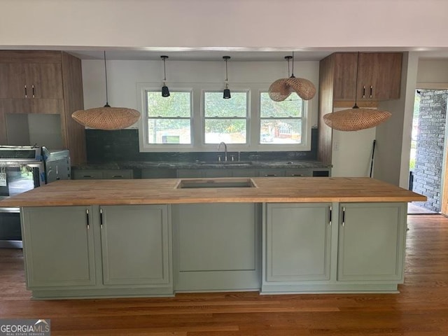 kitchen with butcher block countertops, sink, and a kitchen island