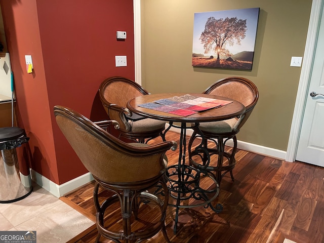 dining room with bar area and hardwood / wood-style flooring