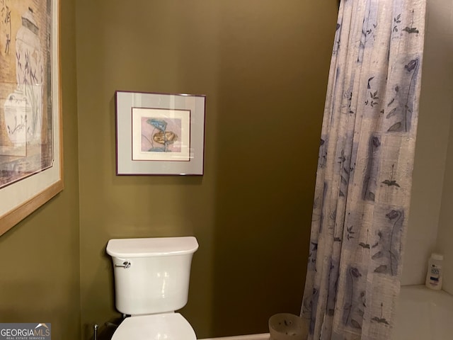 bathroom featuring toilet and shower / bath combination with curtain