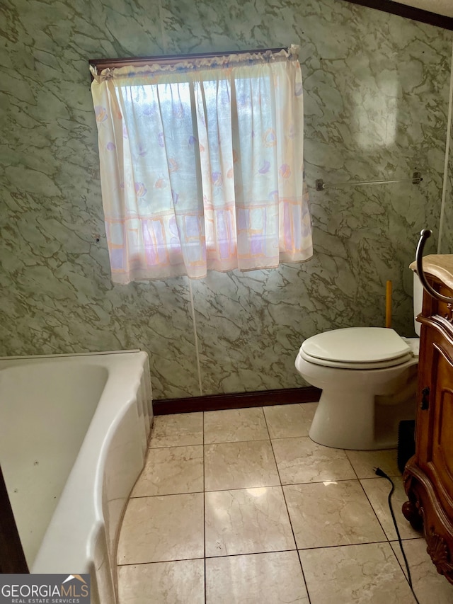 bathroom with vanity, a tub to relax in, and toilet