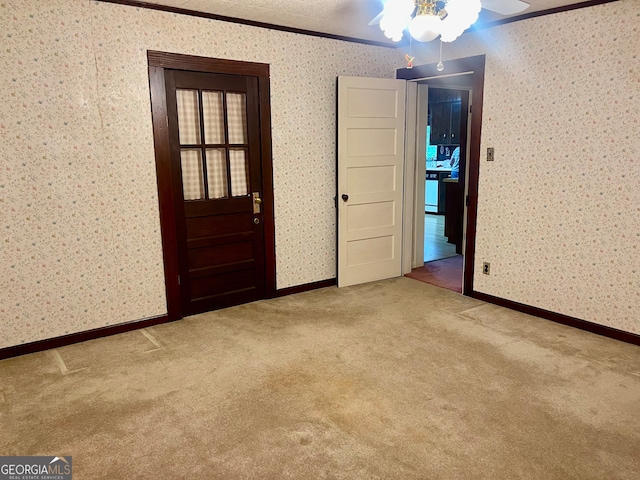 carpeted spare room featuring ceiling fan and ornamental molding