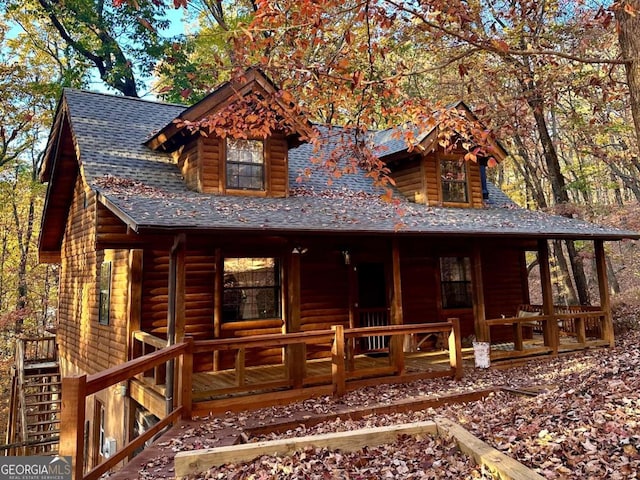 log-style house with covered porch