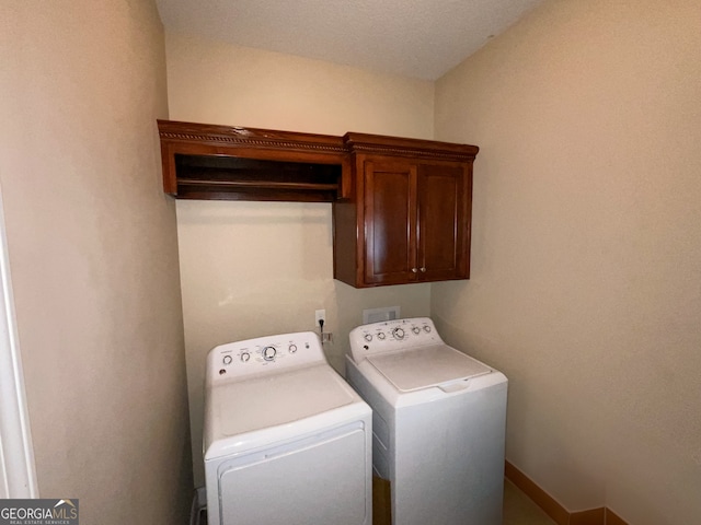 washroom featuring independent washer and dryer and cabinets