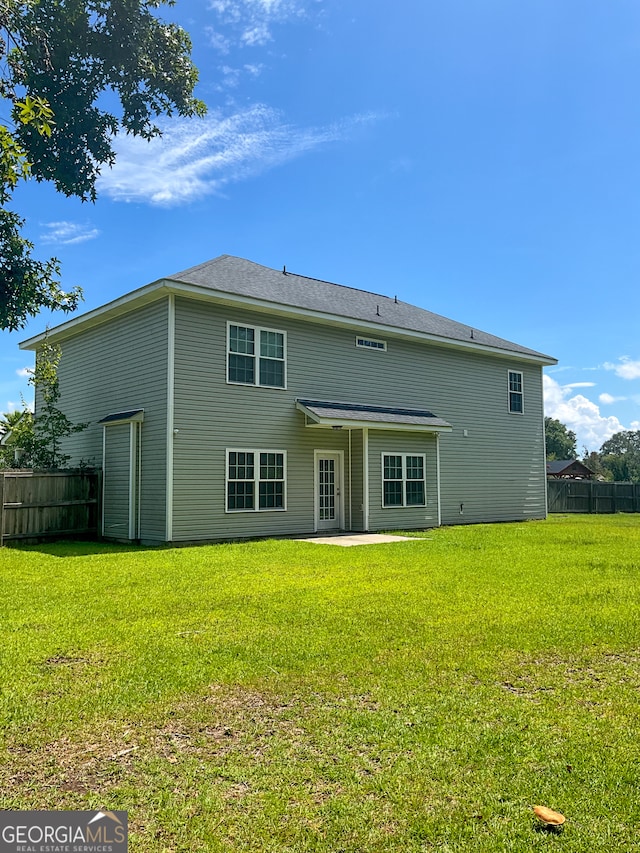 back of property with a patio and a yard