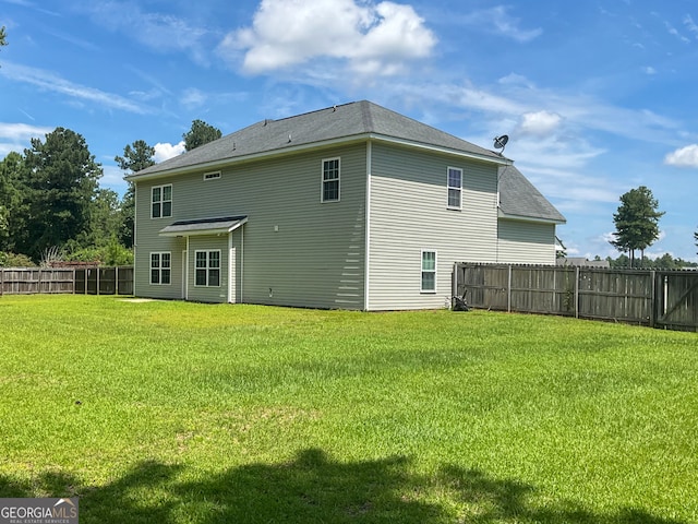 rear view of property featuring a yard