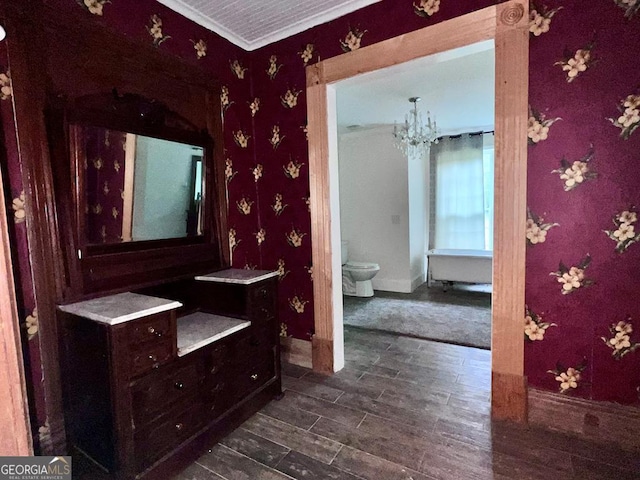 bathroom featuring hardwood / wood-style flooring, toilet, vanity, an inviting chandelier, and ornamental molding