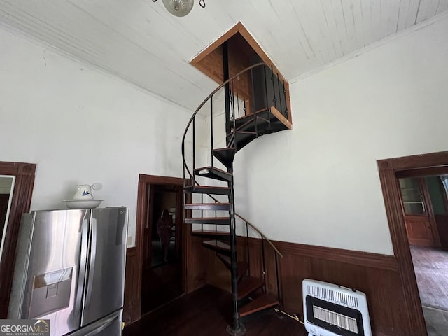 staircase featuring heating unit and hardwood / wood-style flooring