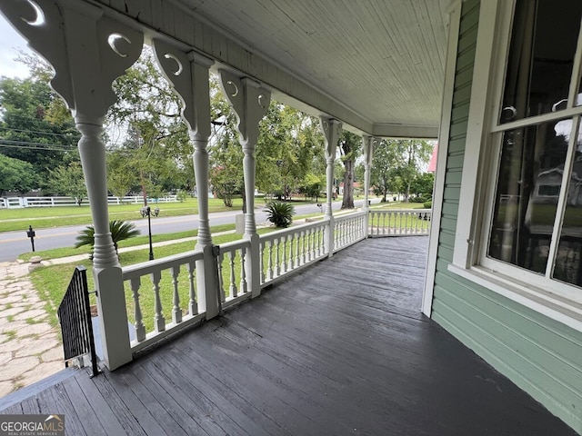 wooden deck featuring a lawn